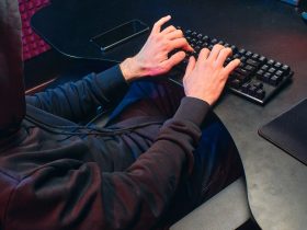 Unrecognizable Person in a Black Hoodie Typing