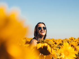 woman in black sunglasses on yellow flower field during daytime
