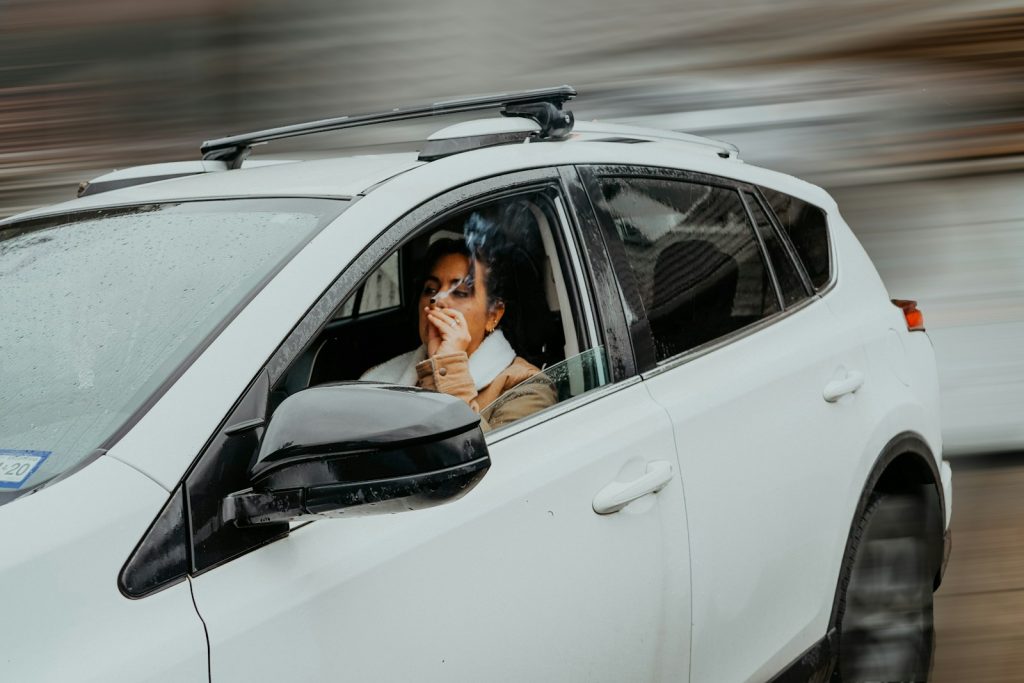 a man sitting in a car talking on a cell phone